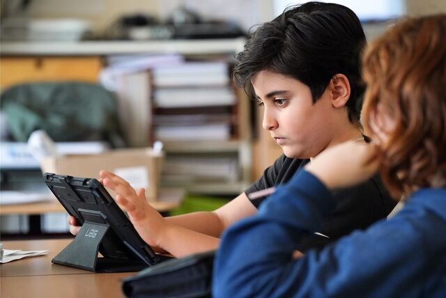 Ein Schüler sitzt an einem Tablet