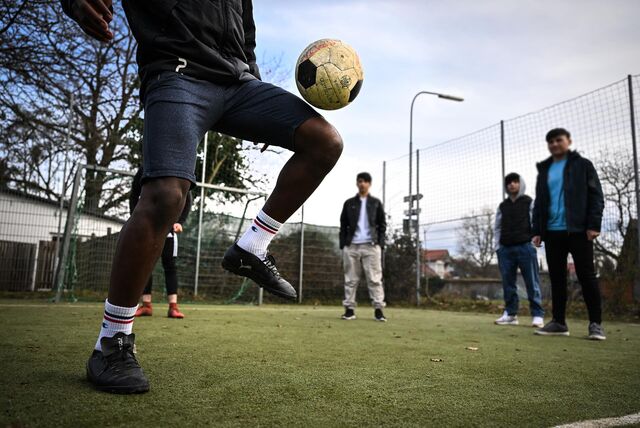 Geflüchtete Jugendliche spielen gemeinsam auf einem Bolzplatz. In Holzwickede sollen Flüchtlinge Kontakte in die Vereine erhalten.