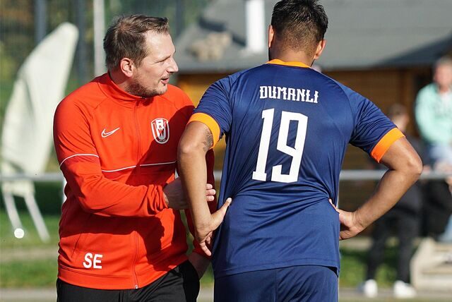RWU-Coach Sebastian Eckei (l.) im Austausch mit TuRa Bergkamens Stürmer Elyesa Dumanli.