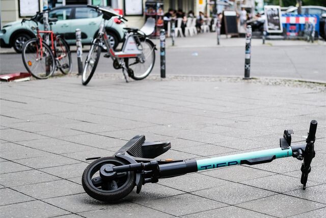 Ein E-Scooter liegt umgekippt mitten auf dem Gehweg