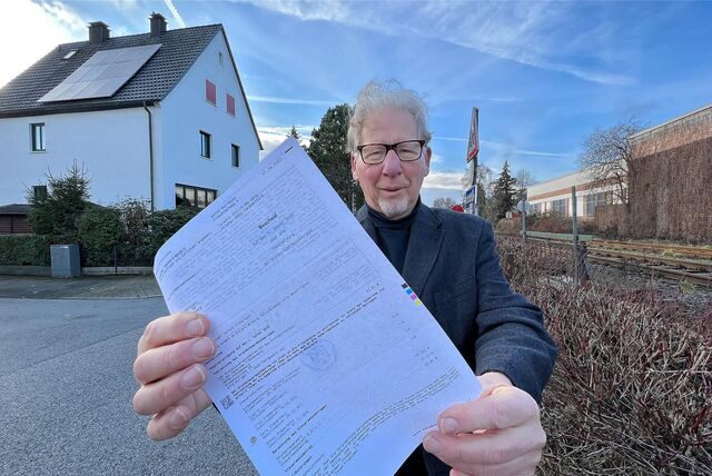 Grundstückseigentümer Bernd Weskamp steht vor seinem Haus in Fröndenberg und hält seinen Messbescheid in der Hand.