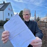 Grundstückseigentümer Bernd Weskamp steht vor seinem Haus in Fröndenberg und hält seinen Messbescheid in der Hand.