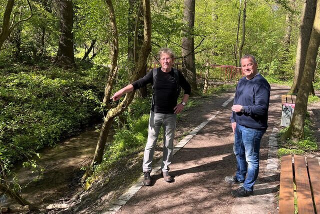 Zwei Mitglieder der Schutzgemeinschaft Bornekamp werfen von einem Wanderweg aus einen Blick in einen der Waldstreifen in dem Naherholungsgebiet.