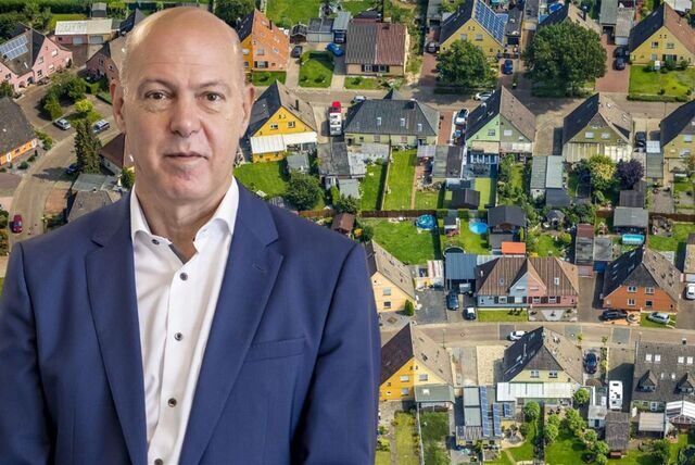 GSW-Geschäftsführer Jochen Baudrexl vor dem Luftbild einer Zechensiedlung.