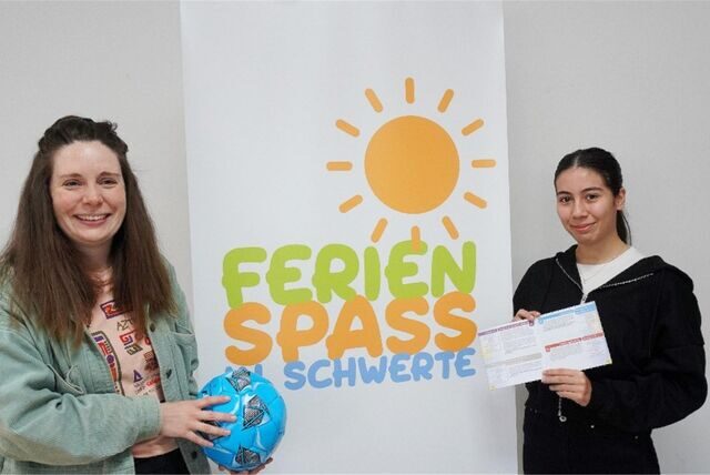 Zu sehen sind zwei junge Frauen vor einem Plakat mit der Aufschrift „Ferienspaß in Schwerte“.