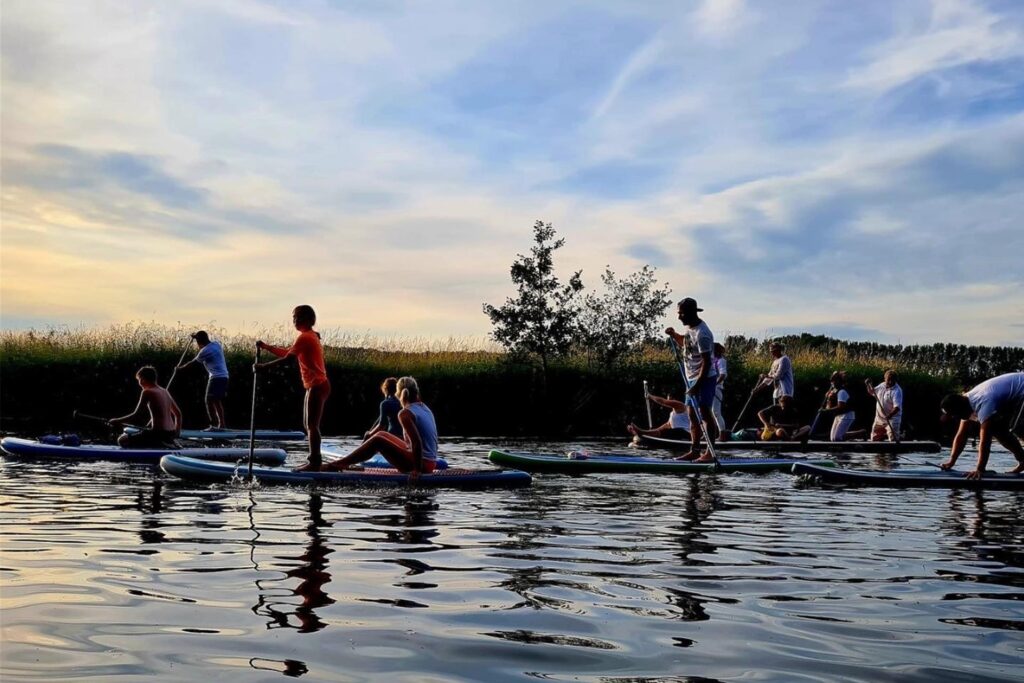 Zu sehen sind viele Menschen auf Stand Up Paddling Boards.