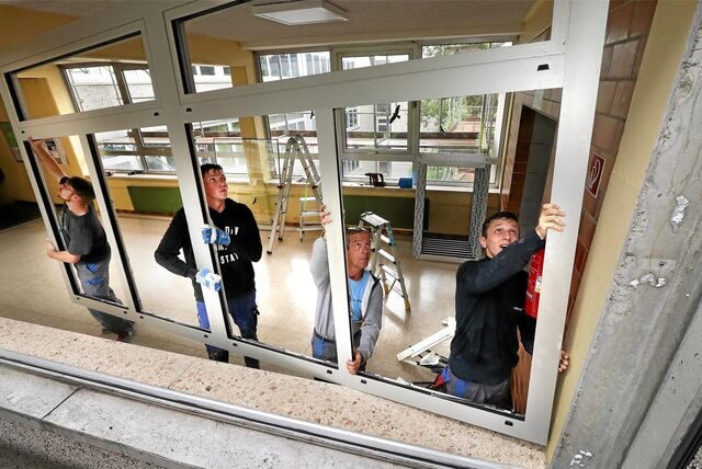 Mitarbeiter einer Fensterbau-Firma bauen neue Fenster am Städtischen Gymnasium ein.
