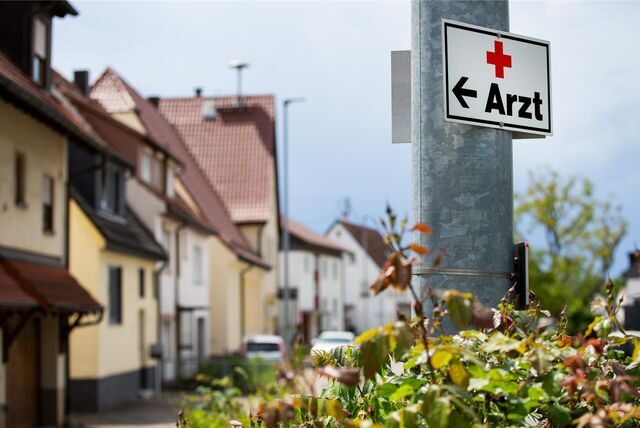 Ein Schild mit der Aufschrift «Arzt» hängt an einer Straßenlaterne.