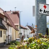 Ein Schild mit der Aufschrift «Arzt» hängt an einer Straßenlaterne.