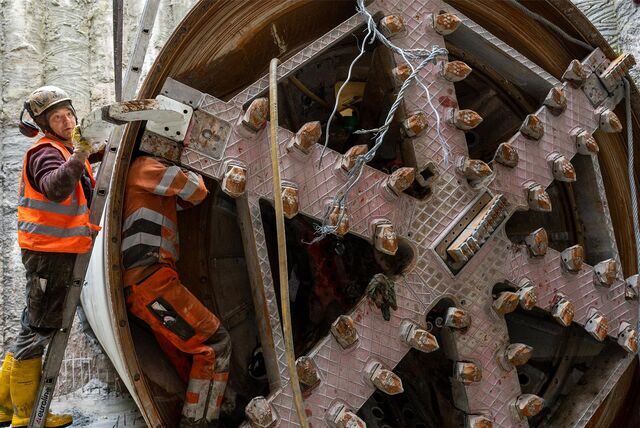 Mitarbeiter entfernen das Schneidwerk an der Fräsmaschine.