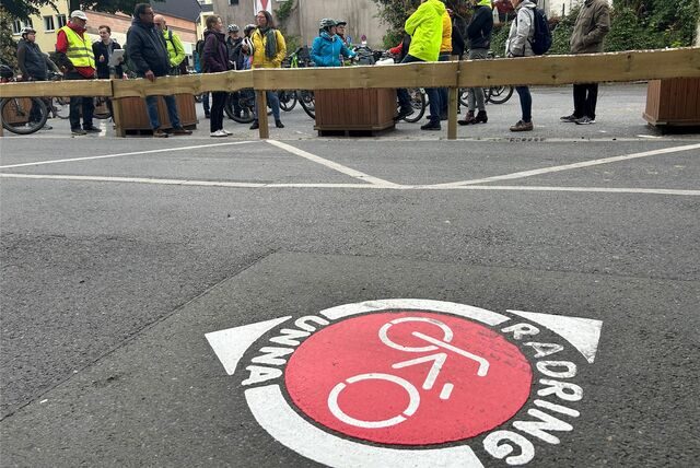 Ein rundes Piktogramm auf dem Asphalt, mit einem Fahrradsymbol in der Mitte, der Aufschrift „Radring Unna „und zwei Pfeilen, die in unterschiedliche Richtungen zeigen.