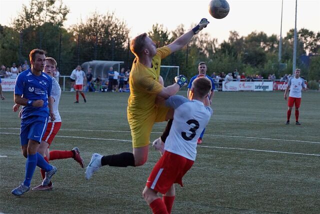Bastian Luncke (in Gelb) faustet einen Ball weg.