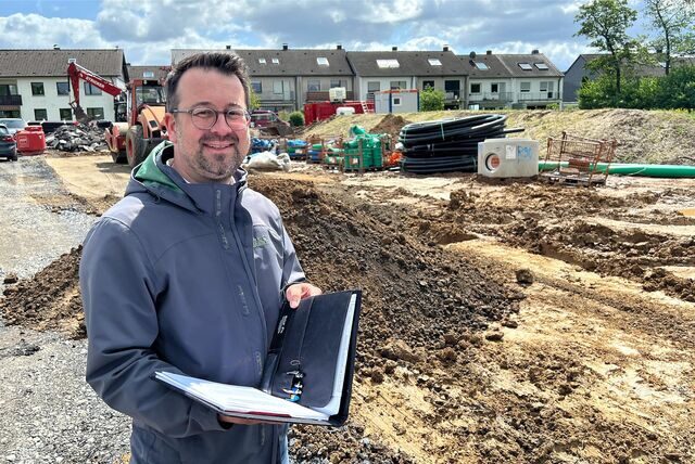 Fröndenbergs Bauamtsleiter Tim Stein steht auf dieser Montage vor einer Baustelle.