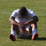 Ein Roj-Spieler sitzt enttäuscht auf dem Rasen.