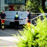 Ein Leichenwagen steht auf einem Schulhof, davor Flatterband sowie Einsatzkräfte von Polizei und Feuerwehr.