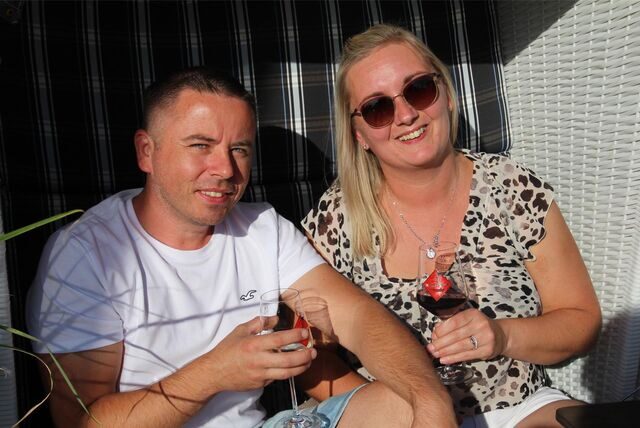 Ein Mann und eine Frau sitzen mit einem Glas Wein im Strandkorb.