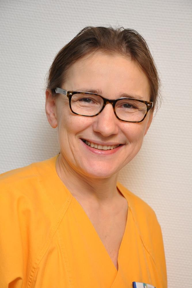 Frau, in die Kamera lächelnd