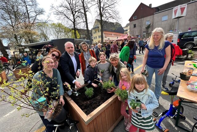 Bürgermeister Dirk Wigant, Frauen und Kinder stehen an einem Pflanztrog an der Schulstraße in Unna.