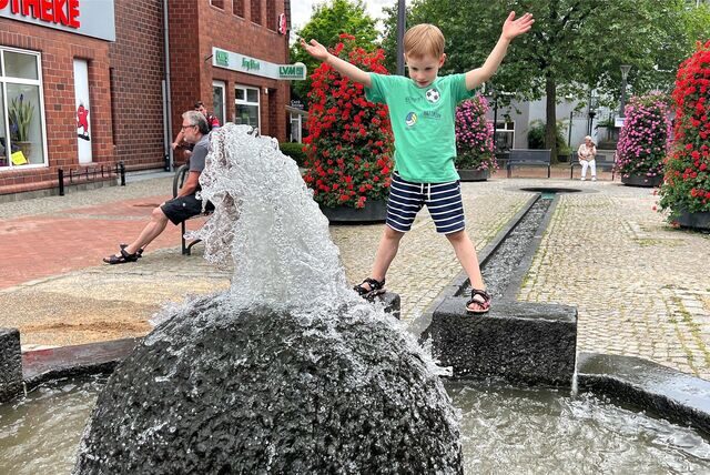 Jona freut sich am Mittwoch, 21. Juni, über den sprudelnden Lichtkunstbrunnen an der Winschotener Straße – Wasser trägt vor allem bei Hitze zu einem besseren Mikroklima in den Innenstädten bei.