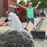 Jona freut sich am Mittwoch, 21. Juni, über den sprudelnden Lichtkunstbrunnen an der Winschotener Straße – Wasser trägt vor allem bei Hitze zu einem besseren Mikroklima in den Innenstädten bei.