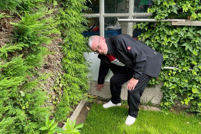 Antonius Schulze Kersting zeigt, wie hoch das Wasser in seinem Garten stand.