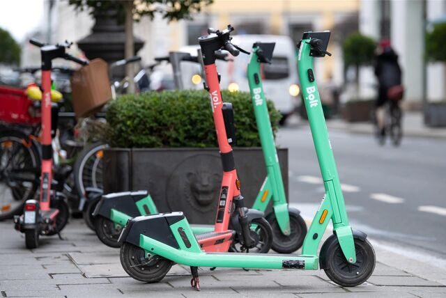 E-Scooter stehen am Rand einer Straße.