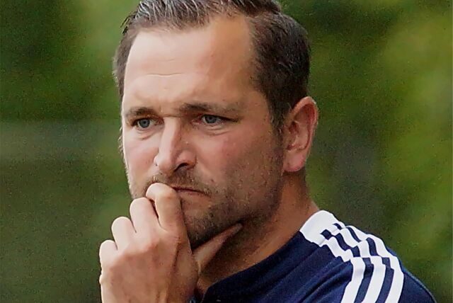Claudio Marzolla schaut mit skeptischen Blick aufs Spielfeld und hält mit seiner Hand sein Kinn.