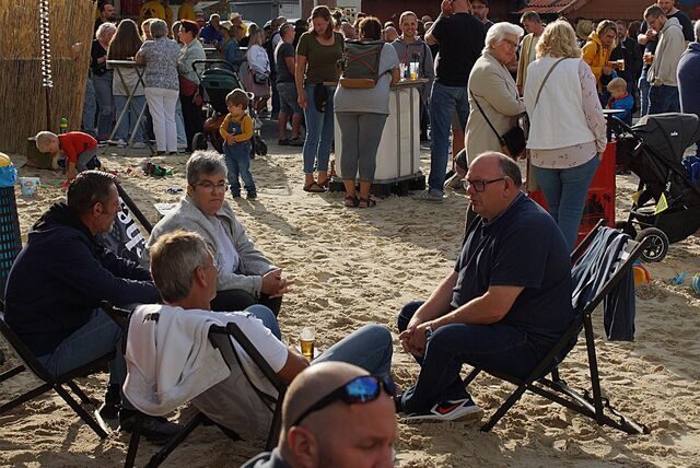 Gäste sitzen in Strandstühlen auf dem Hof des Feuerwehrgerätehauses Heeren.