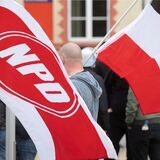 Mit Fahnen ziehen Anhänger der rechtsextremen NPD durch die Innenstadt von Greifswald.