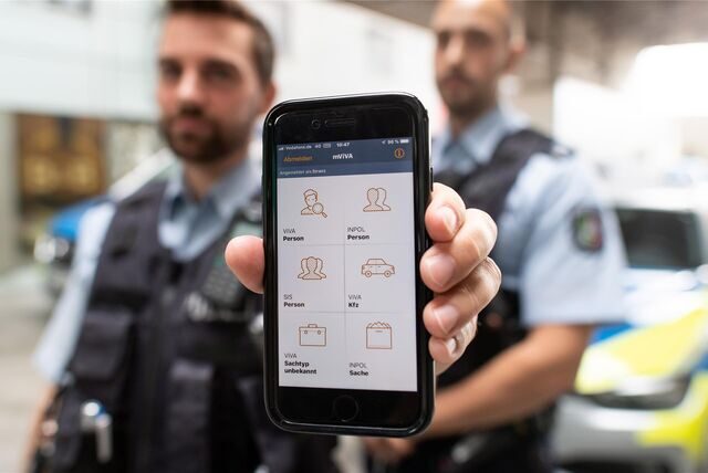 Ein Polizeikommissar demonstriert wie das Tablet für den Einsatz- und Streifendienst funktioniert.