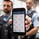 Ein Polizeikommissar demonstriert wie das Tablet für den Einsatz- und Streifendienst funktioniert. 