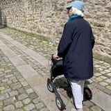 Irmgard Rüsing demonstriert, wie sie mit dem Rollator durch die kleine Gasse am Kloster geht. Dabei bleibt sie schon mal an den defekten Pflastersteinen hängen.