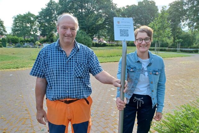 Matthias Wenge vom Bauhof der Gemeinde und Andrea Mennemann von der Friedhofsverwaltung legen die Standorte für die neuen Schilder des digitalen Friedhofsplans fest.