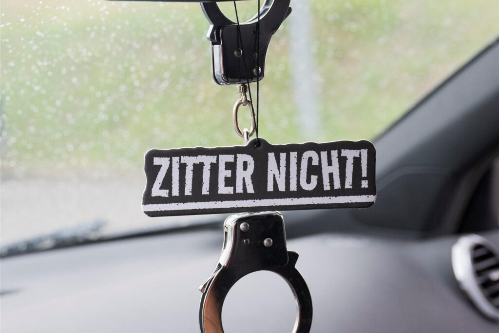 Handschellen und der Schriftzug «Zitter nicht» hängen im Audi einer Autotunerin. 