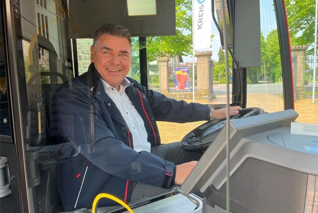 Landrat Mario Löhr sitzt am Steuer eines Busses der VKU