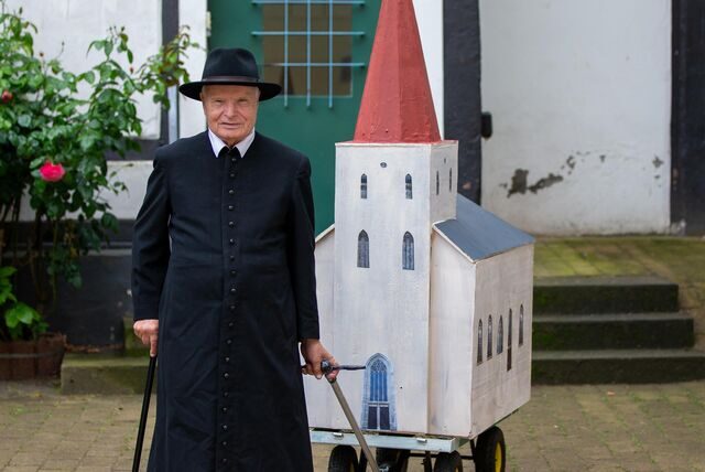 Karnevalist Helmut Scherer zieht ein Modell der Evangelischen Stadtkirche durch Unna.