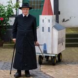Karnevalist Helmut Scherer zieht ein Modell der Evangelischen Stadtkirche durch Unna.