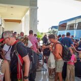 Touristen warten vor ihrem Hotel auf der griechischen Insel Rhodos auf den Einstieg in Busse, um die Insel wegen schwerer, tagelanger Waldbrände zu verlassen.