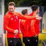 Axel Schmeing spricht mit Spielern auf der Ersatzbank.