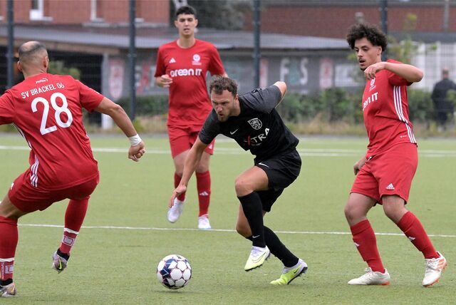 Dominic Schmidt (M.) ist umzingelt von Brackeler Gegenspielern, hat den Ball am Fuß.
