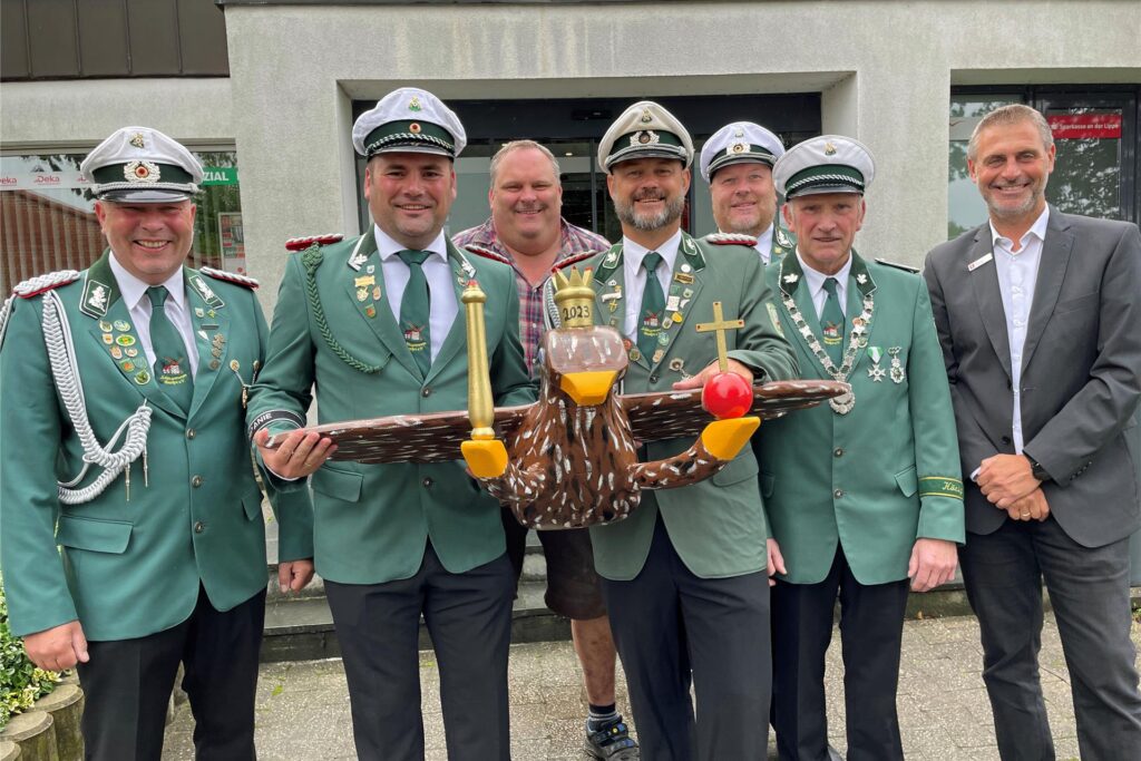 Sieben Mann haben einen Vogel. (V. l.) Vorsitzender Thomas Behrendt, Geschäftsführer Marius Sendermann, Vogelbauer Stefan Hoselmann, 2. Vors. Daniel Krause, Oberst Jörg Kortenstedde, König Ludwig Marckhoff und Sparkassen-Filialleiter Jörg Lütkemeier.