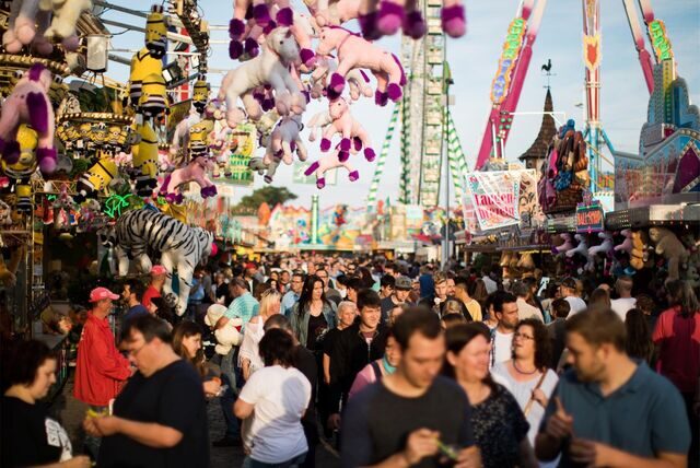 Menschen gehen über die Cranger Kirmes in Herne.