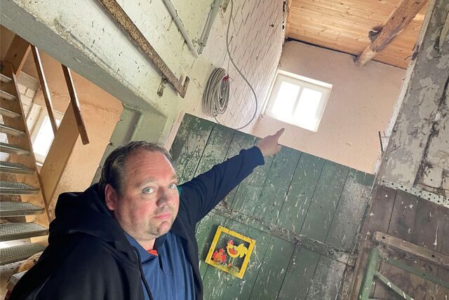 Stefan Suerhoff deutet auf eines der 13 Schwalbennester in der Tenne seines Hofes, die er eigens für die Tiere offen lässt.