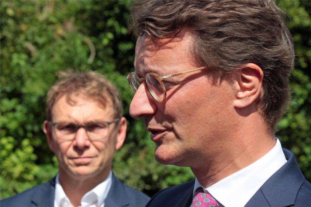 Ministerpräsident Wüst beantwortet Fragen der Medien. Bürgermeister Christ hört im Hintergrund aufmerksam zu.