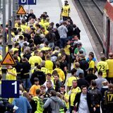 Fans von Borussia Dortmund steigen gerade aus einem Zug aus, der am Bahnhof des Stadions, Signal Iduna Park, hält.