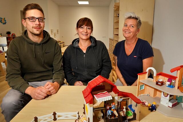 Marvin Engemann, Julia Herdieckerhoff und Melanie Nieballa-Grötken (v.l.) sitzen an einem Tisch in der Kindertagesstätte Am Grimberg.
