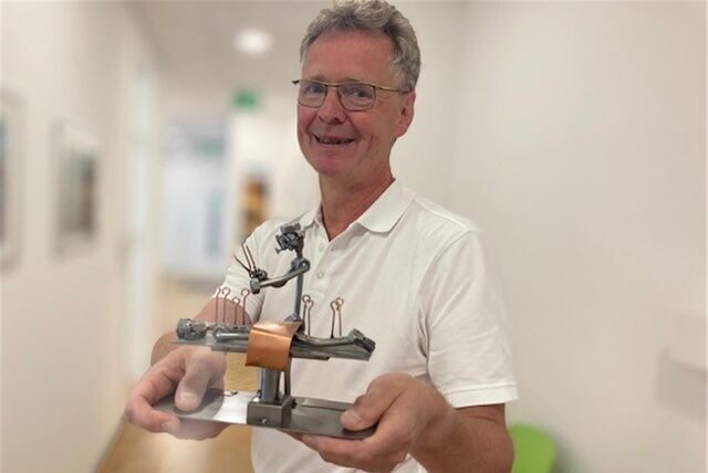 Der Christian Geiping mit einer Figur in der Hand.