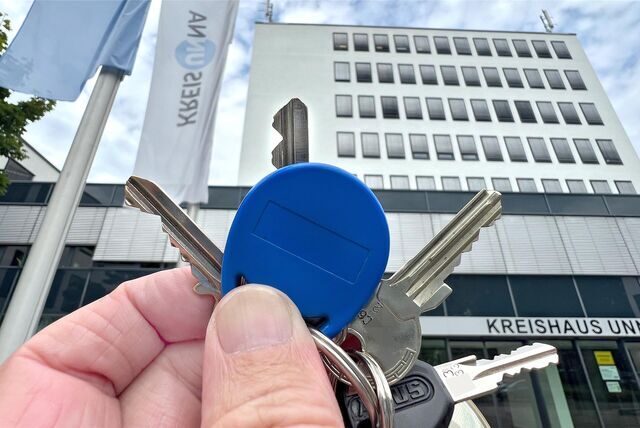 Eine Hand hält einen Token vor dem Kreishaus in Unna.