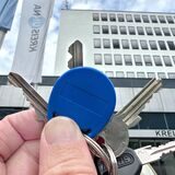 Eine Hand hält einen Token vor dem Kreishaus in Unna.