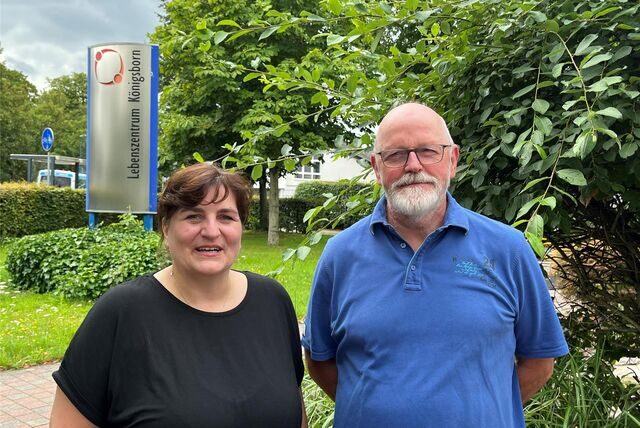 Eine Frau und ein Mann stehen vor einem Schild des Lebenszentrums Königsborn.